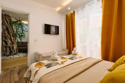 a bedroom with a bed and a window with orange curtains at Eman Resort in Ulcinj