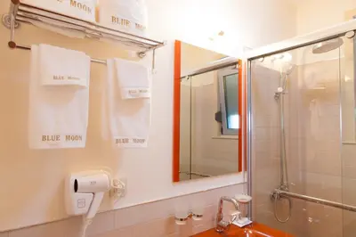 a bathroom with a shower and a sink and a mirror at Hotel Blue Moon in Ulcinj