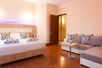 a large bedroom with a bed and a couch at Hotel Blue Moon in Ulcinj