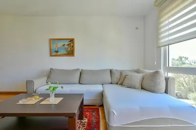 a living room with a white couch and a table at Lux Apartman Sofia in Sveti Stefan
