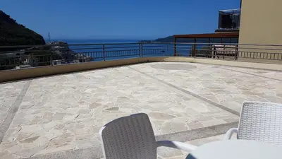 a patio with a table and chairs on a balcony at Lux Apartment Vidovic in Rafailovici