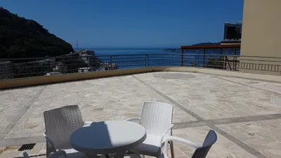 a table and chairs on a balcony with the ocean at Lux Apartment Vidovic in Rafailovici