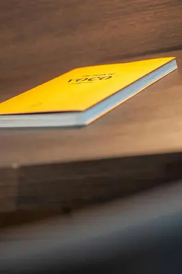 a yellow book sitting on top of a table at voco - Podgorica by IHG in Podgorica