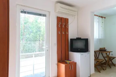 a room with a television and a door to a balcony at Apartments Lora in Bar