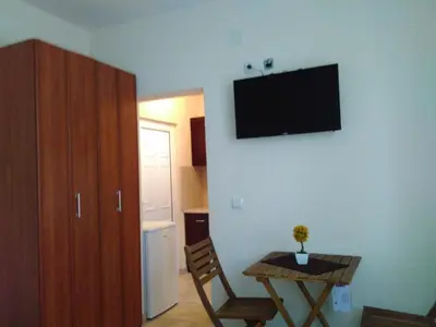a room with a table and a television on a wall at Apartments Lora in Bar