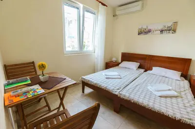 a bedroom with a bed and a table and a desk at Apartments Lora in Bar