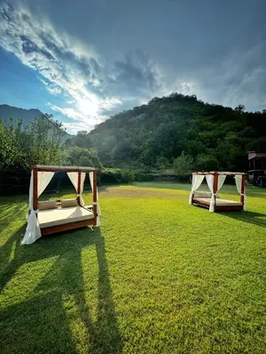 two beds in a field with a mountain in the background at Apartments Djurovic in Virpazar