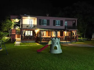 a house with a playground in the yard at night at Apartments Djurovic in Virpazar