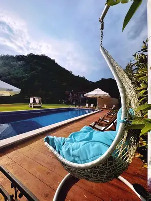 a hammock on a deck next to a swimming pool at Apartments Djurovic in Virpazar