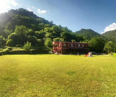 a house in the middle of a large grass field at Apartments Djurovic in Virpazar