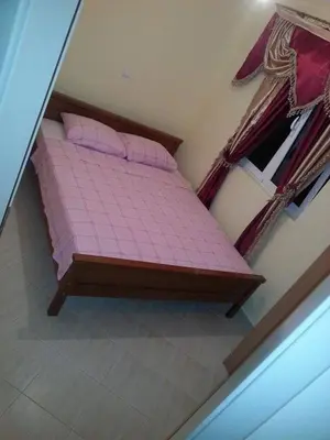 a bedroom with a pink bed with pink sheets at Ago Apartmani in Dobra Voda