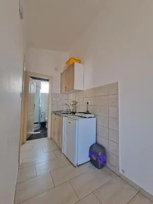 a kitchen with a white refrigerator and a tile floor at Ago Apartmani in Dobra Voda