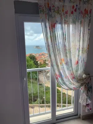 a window with a view of the ocean at Urban Apartment in Petrovac na Moru