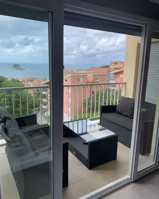 a balcony with a couch and a coffee table at Urban Apartment in Petrovac na Moru