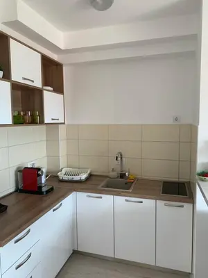 a kitchen with white cabinets and a sink at Urban Apartment in Petrovac na Moru