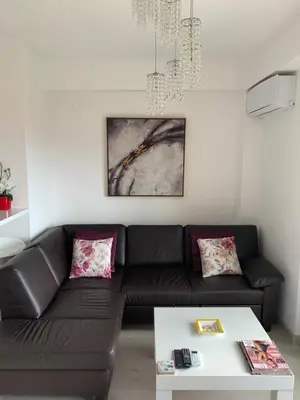 a living room with a black couch and a white table at Urban Apartment in Petrovac na Moru