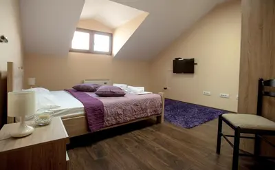 a bedroom with a bed with purple sheets and a window at Apartman in Danilovgrad