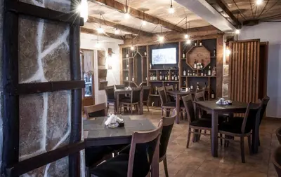 a restaurant with wooden tables and chairs and a television at Apartman in Danilovgrad