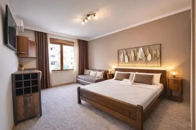 a hotel room with a bed and a couch at Heart of the City Stunning city View,Balcony Free Wi-Fi in Podgorica