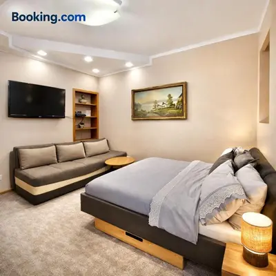 a bedroom with a bed and a couch at Heart of the City Stunning city View,Balcony Free Wi-Fi in Podgorica