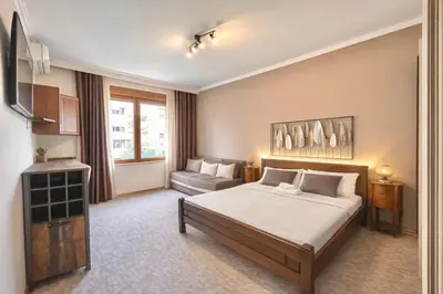 a bedroom with a bed and a couch in it at Heart of the City Stunning city View,Balcony Free Wi-Fi in Podgorica