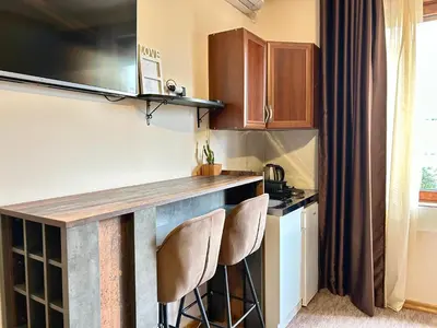 a kitchen with a counter and two stools at Heart of the City Stunning city View,Balcony Free Wi-Fi in Podgorica