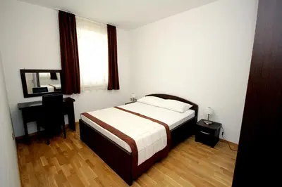 a bedroom with a bed and a desk and a window at Apartments Drašković Mirišta in Petrovac na Moru