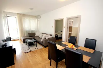 a living room with a table and a couch at Apartments Drašković Mirišta in Petrovac na Moru