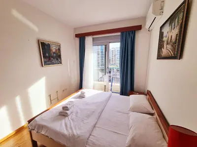 a bedroom with a white bed with a window at Centar New Loki Apartments in Budva