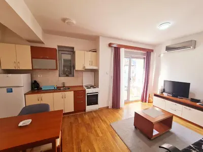 a living room with a kitchen and a table at Centar New Loki Apartments in Budva