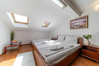 a bedroom with two beds in a room with skylights at SMS Apartments in Budva