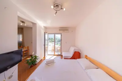 a white living room with a table and a couch at SMS Apartments in Budva