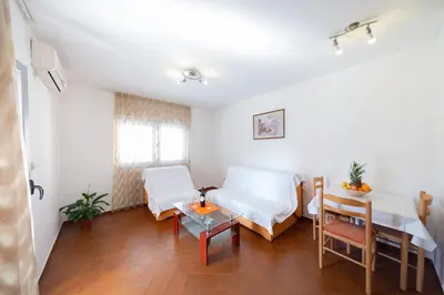 a living room with two beds and a table at SMS Apartments in Budva