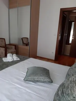 a white bed with a pillow on top of it at City & Sea Apartments in Budva