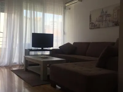 a living room with a couch and a tv at City & Sea Apartments in Budva
