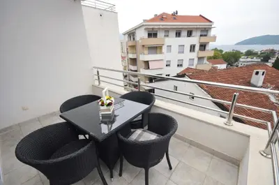 a balcony with a table and chairs on a building at City & Sea Apartments in Budva