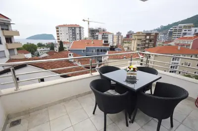 a balcony with a table and chairs on a roof at City & Sea Apartments in Budva