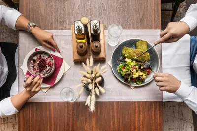 two people sitting at a table with a plate of food at Crowne Plaza Podgorica by IHG in Podgorica