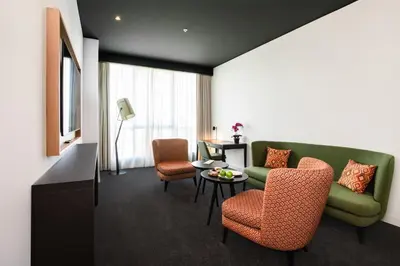 a living room with a green couch and chairs at Crowne Plaza Podgorica by IHG in Podgorica