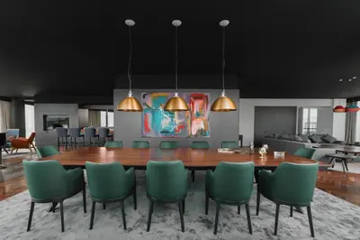 a dining room with a table and green chairs at Crowne Plaza Podgorica by IHG in Podgorica