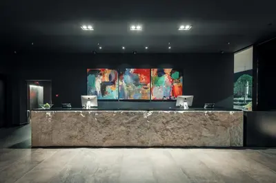 a lobby with a marble counter with paintings on the wall at Crowne Plaza Podgorica by IHG in Podgorica
