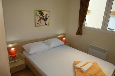 a small bedroom with a white bed with a window at Villa Franeta Apartments in Budva