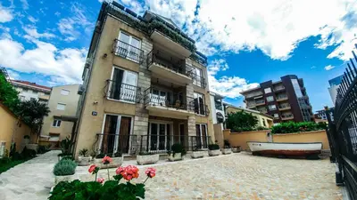 a large building with flowers in front of it at Villa Franeta Apartments in Budva