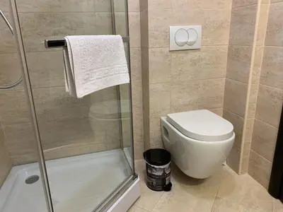a bathroom with a toilet and a glass shower at Karina Apartment in Budva