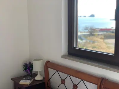a bedroom with a window and a table with a lamp at Karina Apartment in Budva