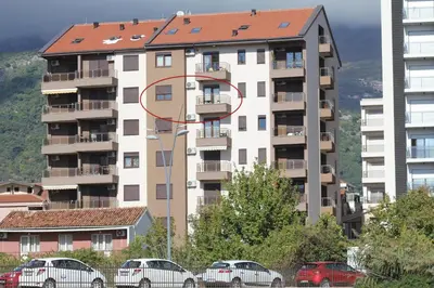 a tall apartment building with a red circle on it at Karina Apartment in Budva