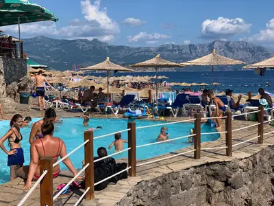 a group of people in a swimming pool at a beach at Karina Apartment in Budva