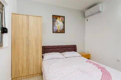 a bedroom with a bed and a wooden cabinet at MC Apartments in Ulcinj