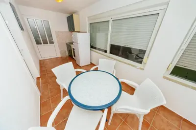 a table and chairs in a room with a kitchen at MC Apartments in Ulcinj