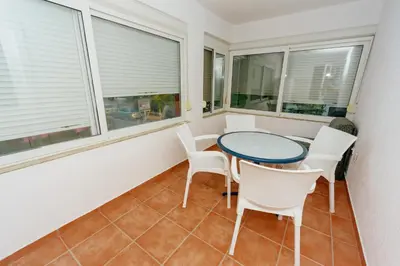 a balcony with a table and chairs and windows at MC Apartments in Ulcinj